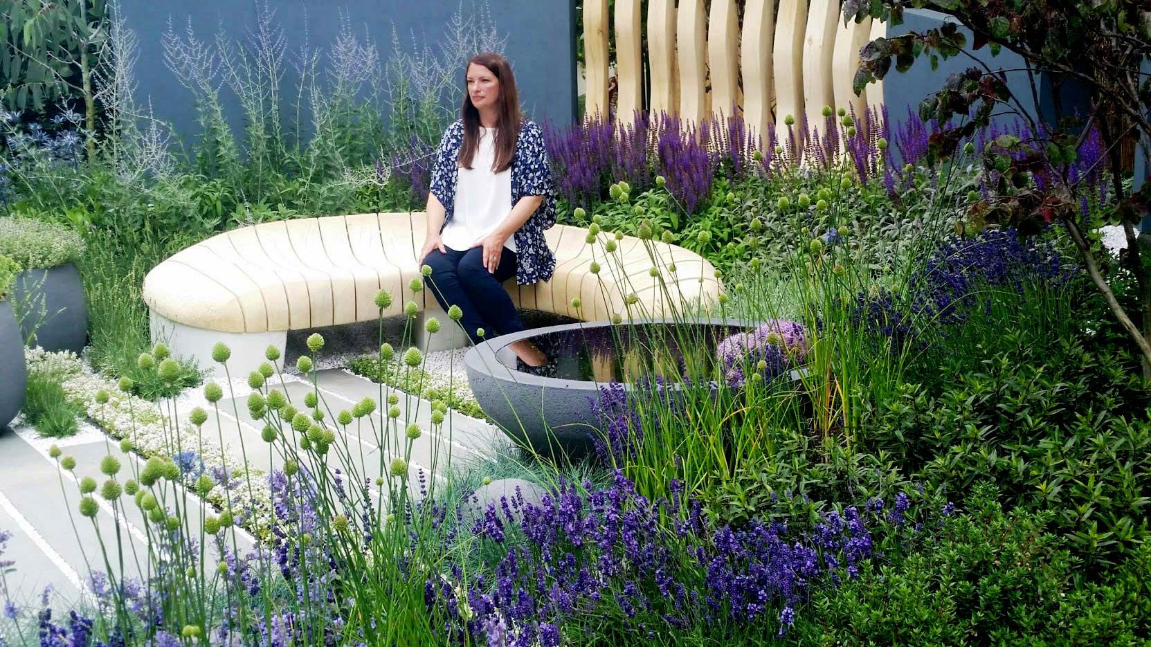 Rachel de Thame sitting in Rae Wilkinson's RHS Hampton Court garden. Rae Wilkinson Garden and Landscape Design Surrey, Sussex, Hampshire, London, South-East England