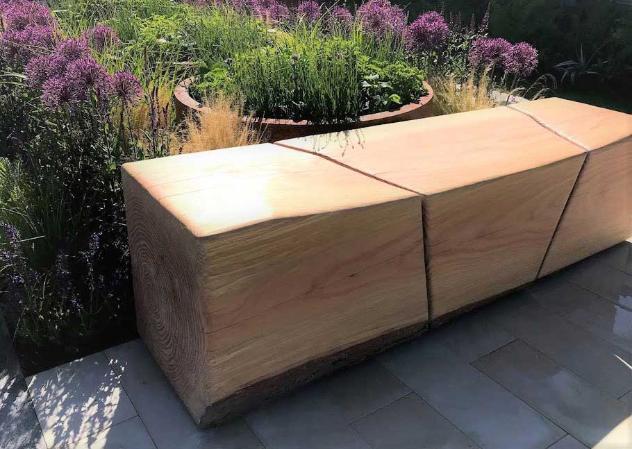 Rae Wilkinson's Chelsea Show Garden with detail of bespoke wooden bench. Rae Wilkinson Garden and Landscape Design Surrey, Sussex, Hampshire, London, South-East England